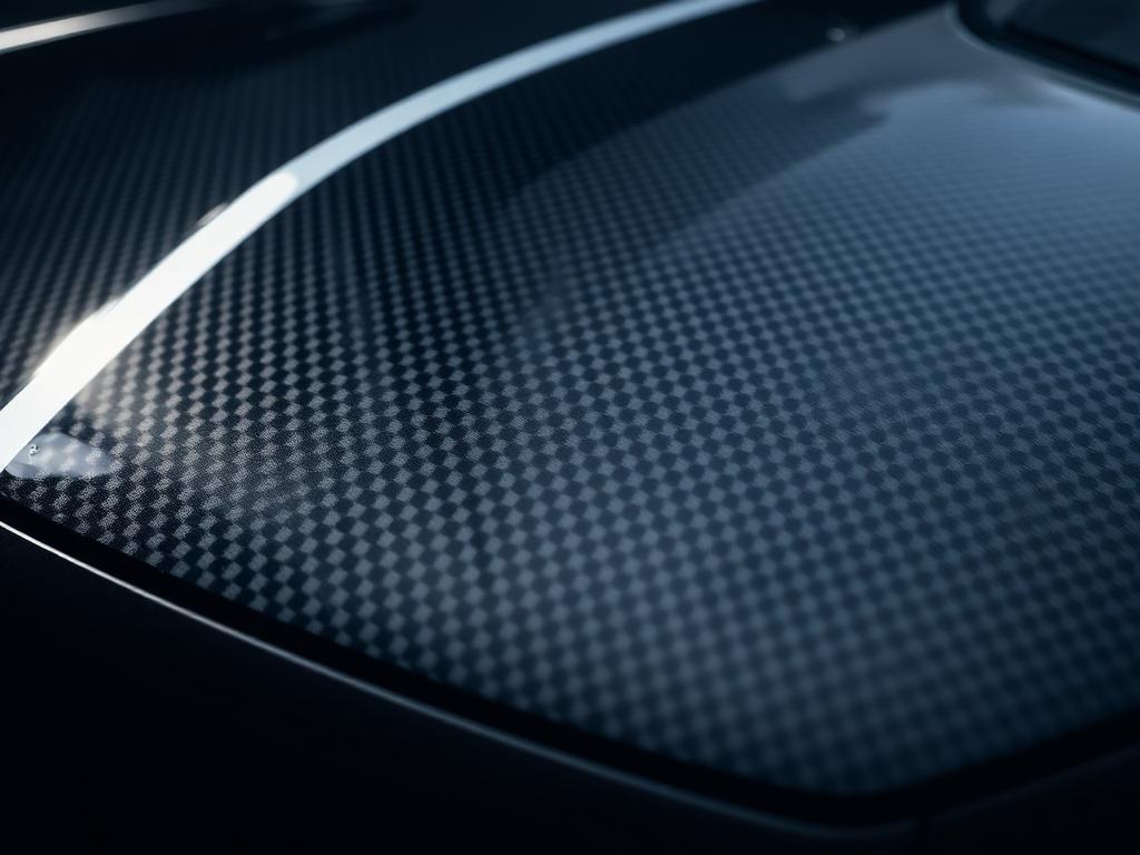 Carbon fibre bonnet detail catching the shop lights